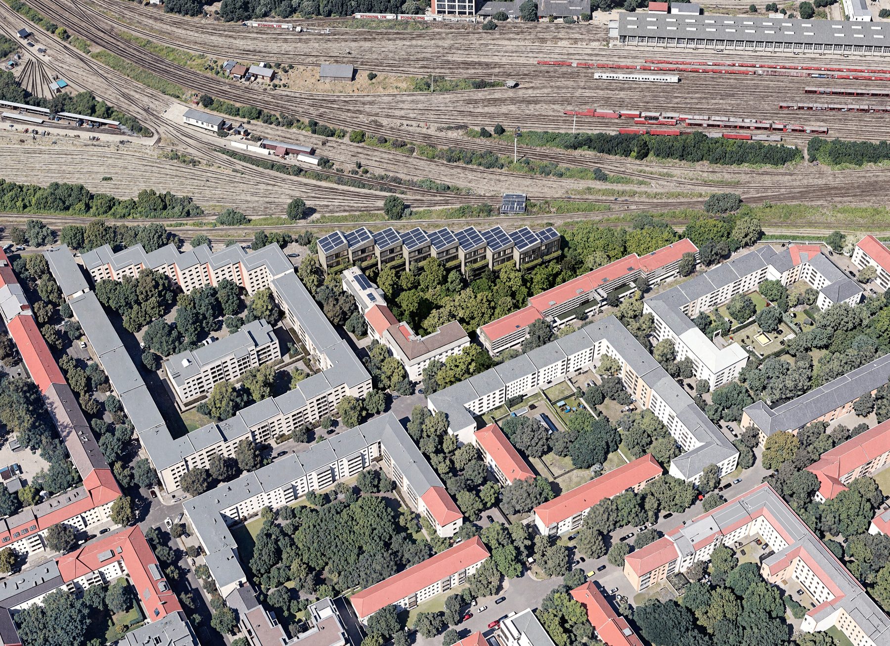 Aerial view of the Münsterland Studios site in Berlin-Lichtenberg, showing block-edge urban context and railway corridor